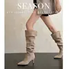 Botas vintage de bico fino, salto agulha e cano alto, que podem ser usadas de duas maneiras, criando um efeito emagrecedor com seu design plissado.