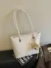 Bolsa tote feminina casual retrô de design requintado estilo coreano 2026 cor sólida com pingente nova moda tendência de ombro único