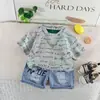 Conjunto de Verão Moderno com Manga Curta para Meninos 2026 Novo Conjunto de Verão Conjunto de Manga Curta para Meninos com Corrente e Estampa Total em Inglês Conjunto Tendência