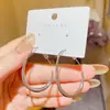 Pendientes geométricos minimalistas y elegantes con una estética metálica, que presentan un diseño único y un atractivo versátil, perfectos para las nuevas joyas de oreja de moda de 2026