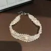 Pulseira de pérolas de vidro frias e transparentes com contas, design simples, delicado e versátil, pulseira nicho, senso de alta qualidade, joia de mão feminina