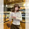 Jaqueta cardigan simples de gola polo na cor aveia para mulheres, combinada com um suéter, novo estilo da primavera de 2026, top de tricô de alta qualidade