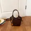 Bolsa pequena casual simples transfronteiriça para mulheres, nova moda 2026 bolsa de mão para o dia a dia, bolsa tipo balde estilosa com textura de estilo estrangeiro, bolsa transversal