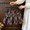 Conjunto de estilo coreano para niñas, nueva colección de otoño para bebés: un cárdigan con volantes con diseño de dos piezas falso, combinado con una falda plisada a cuadros