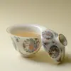 En las montañas, pinos y mariposas danzan entre las flores.; un cuenco de té de cerámica pintado de rosa, hecho a mano con un cuerpo delgado que no quema la mano, es parte del juego de té Kung Fu