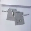 Bolsa pequeña para empaque de joyería, con un delicado cierre de cordón de terciopelo, material de gamuza gris duradero de una sola cara y letras impresas