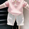 Ropa infantil coreana 2026 primavera y otoño nuevo conjunto de suéter de punto con cuello polo a rayas rosas y pantalones casuales blancos