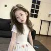 Conjunto de Alta Calidad para Niñas Verano 2026 Nuevo Estilo Camiseta de Manga Corta Lisa para Niños y Falda Blanca Estampada para Niños Mayores