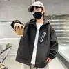 Nueva chaqueta cortavientos con capucha para niño de otoño y primavera, con colores contrastantes, bolsillos con cremallera, corte holgado y un diseño elegante y moderno.