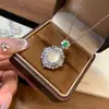Pingente de calcedônia tipo gelo totalmente cravejado de diamantes para mulheres, apresentando uma vibrante pedra preciosa pequena olho de gato verde e branca, uma corrente delicada e uma corrente para clavícula, oferecendo um toque de luxo discreto.