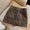 Falda corta de cuero PU media falda mujer 2026 Otoño Invierno nuevo estilo cintura alta falda negra chica popular línea A envolvente de cadera falda corta de cuero