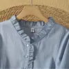 Foto real do novo vestido de verão de 2026, de corte solto, comprimento médio, decote V, com amarração na cintura, manga três quartos, feito de algodão e linho, com acabamento em babados