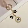Llavero de estilo coreano inspirado en Chanel, superventas transfronterizo, con un elegante lazo de perlas y decoración de rosa para bolsos de mujer