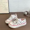 Tênis de lona estilo retrô com estrelas para campus feminino, novo modelo versátil de verão 2026 para estudantes, sapatos brancos da moda para mulheres