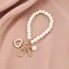 Suministra y Vende Placas de Nombre de Concha en Forma de Corazón, Cadenas de Perlas de Imitación, Llaveros, Fundas para Teléfono, Colgantes para Teléfono y Colgantes para Bolsos