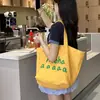 Bolsa de Lona Estampada Versátil com Letras Coreanas Verão 2025 Design de Nicho Grande Capacidade Bolsa Tote de Ombro para o Dia a Dia
