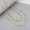 Collar de cadena de cuentas de frijol dorado de doble capa con diseño de celebrante de Internet europeo y americano, cadena de clavícula de acero de titanio a juego para mujer.