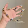 Pendientes huecos de lujo ligero estilo palacio con incrustaciones moradas y ondas doradas, un collar lujoso y sofisticado para el vestido de noche de una socialité