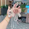 Moda Coreana Piel Camelia Cuerda Trenzada Llavero Creativo Cadena de Perlas Pu Cuero Rosa Colgante de Bolsa Regalo