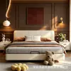 Cama matrimonial de color crema, diseño flotante, sin cabecero, con tira de iluminación LED debajo de la cama, unidad de almacenamiento de gran capacidad en el dormitorio principal y una estructura de cama cubierta de cuero.