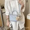Bolso tipo cubo para el día a día en color crema para mujer 2026 Modelo Nuevo Bolso de un solo hombro cruzado Superficie suave Color sólido Moderno Sensación de alta gama