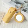 Mini llavero de lipstick portátil, bolsa redonda de cuero con espejo de maquillaje, accesorio para niñas, colgante de bolsa de espejo de maquillaje portátil