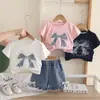Nuevo conjunto de verano 2026 estilo coreano de manga corta para niñas, con camiseta de cuello redondo y diseño de lazo, perfecto para bebés niñas