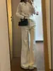 Jeans beige de mujer petite ligeramente acampanados, un estilo popular de otoño-verano, no se pegan a las piernas, estilizan, con una bonita caída, pantalones versátiles de largo hasta el suelo