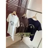 Camiseta de Manga Corta con Cuello Redondo, Hombro Normal, Corte Ajustado Ligeramente Cónico, Patrón de Trébol de Cuatro Hojas, Algodón Peinado de Alta Calidad, Estilo Retro Americano H053111