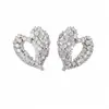 Pendientes de aguja plateada con diseño de corazón hueco incrustado con circonita, pendientes de moda de nicho únicos y elegantes, sensación de lujo ligero y alta gama, venta al por mayor
