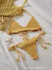 Conjunto de biquíni handmade de crochê com amarração no pescoço para mulheres, apresentando contas de madeira coloridas e franjas, perfeito para férias ou um passeio na praia