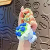 Llavero creativo de ganchillo de lana sosteniendo una flor lindo llavero de flor artificial colgante de peluche para bolso de niña regalo