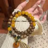 Pulsera de madera de agar, accesorio cultural de madera, hebilla de paz de ámbar y hueso de camello de segunda generación, borla de doble bucle, con bloques de color, elegante y vintage para mujer