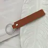 Llavero de PU de color sólido transfronterizo creativo de color caramelo banda ancha de cuero cuerda para la mano simple para llaves de coche de hombre venta al por mayor