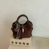 Bolso pequeño de alta gama, de nicho, súper popular para el trabajo, nuevo bolso cubo de hombro y cruzado para mujer 2026