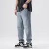 Atacado de roupas masculinas Xintang: Jeans retrô novo de primavera para homens, estilo harém solto, marca da moda com furos, calça comprida de primavera