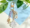 Llavero de Flor de Hilo de Colores con Cuentas Flor Azul Fresca Ramas y Hojas de Rosa Llavero de Metal Encanto de Bolso Suave y Femenino
