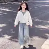 Nova coleção Primavera e Outono: conjunto moderno de duas peças para meninas, apresentando um top estiloso com capuz e design de peça dupla falsa, combinado com calças jeans com estampa de estrelas