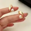 Pendientes de botón de perla curvada esmerilada con pasador de plata de ley S999 para mujer, sensación de alta gama, pendientes de moda de lujo ligero, nuevos accesorios para pendientes de verano 2026