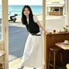 Atuendos para Personas Petites: un Conjunto Completo de Verano con una Camiseta Base Única y Impresionantemente Hermosa, un Top sin Mangas de Lunares y un Conjunto de Tres Piezas con Falda