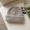 Venta al por mayor de fábrica de gorros de punto listos para enviar, sencillos, suaves y acogedores para hombres y mujeres, con una mezcla de lana para mayor calidez y protección para los oídos en invierno