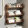 Baño de estilo abierto con un inodoro, un soporte para pañuelos de papel y toallitas húmedas encima del inodoro, y un estante de pared para toallas perfumadas