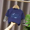 Camiseta de manga larga de algodón puro para niño 2026 primavera y otoño nueva elegante de dibujos animados estilo dos piezas falsas camiseta base de primavera para niño