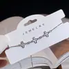 Pulseira Branca de Madrepérola de Luxo Leve para Mulheres, Design de Nicho de Alto Padrão, Flor de Quatro Folhas, Zircônia em Forma de Coração, Joia de Mão Ajustável Venda por Atacado