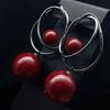 Pendientes elegantes de lujo con forma de botón y cuentas rojas, estilo retro, de aleación, con un anillo envolvente sencillo y exquisito.