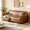 Sofá de estilo de mediados de siglo, color blanco roto, de piel sintética, con reposabrazos redondeados de forma única, cojines de asiento segmentados y diseño de pie, adecuado para una sala de estar como sofá de línea recta