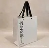 Bolsa de tote de papel recubierto impresión de LOGOTIPO personalizado fabricante venta al por mayor bolsa de regalo color blanquecino bolsa de compras impresión personalizada