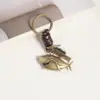 Llavero creativo para hombres y mujeres, pequeño regalo, aleación, lindo animal de aleación, llavero de cuero tejido vintage, llavero