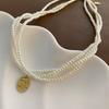 Collar francés de perlas de vidrio multicapa para mujer, cadena de clavícula de nicho de diseño de alta gama, nueva moda de otoño e invierno, personalidad y temperamento.