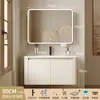 Tocador de baño engrosado y ahorrador de espacio con diseño en color crema, que cuenta con un lavabo redondeado, lavabo cerámico integrado y un lavabo de una sola pieza.